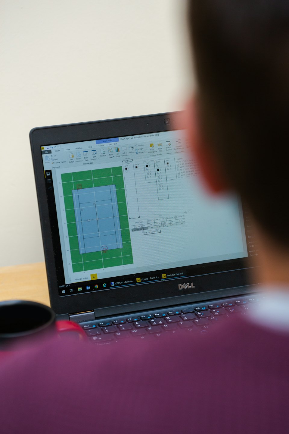 Business person analyzing data on laptop screen.
